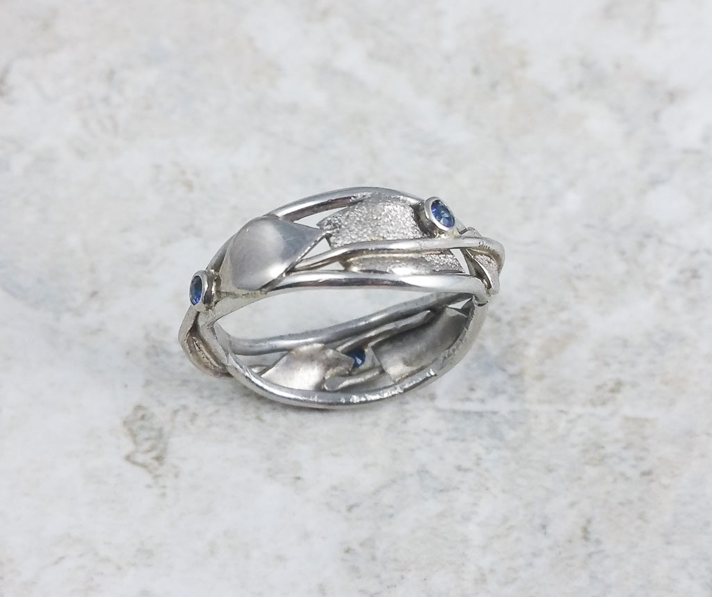 Leaf and vine wavy band in white gold with sapphire accent