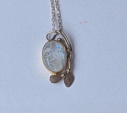 Carved moonstone face set in white gold pendant