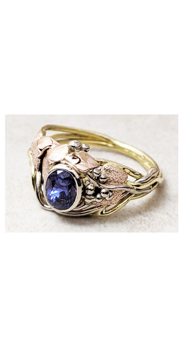 Asymmetrical design ring with bezel set purple sapphire