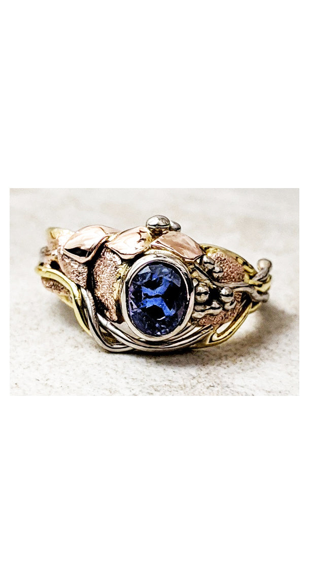 Asymmetrical design ring with bezel set purple sapphire